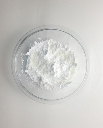 Ingredients in a glass bowl to make a lemon glaze for a lemon bundt cake.