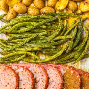 Sheet pan ham dinner with green beans and yellow potatoes.