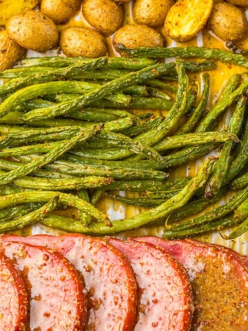 Sheet pan ham dinner with green beans and yellow potatoes.