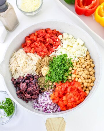 A large mixing bowl with ingredients to make stuffed peppers greek style