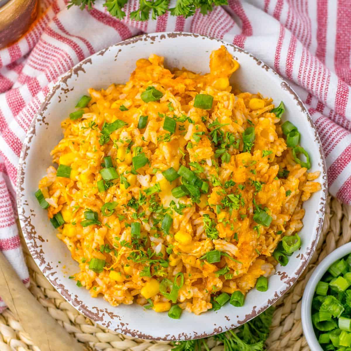 Chicken rice enchilada casserole in a bowl topped with chopped green onions and chopped cilantro.