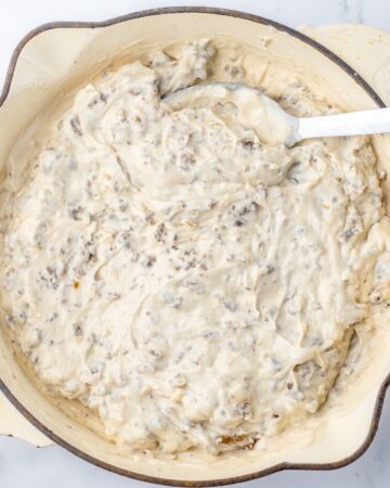 A saute pan with the ingredients to make a ground beef french onion sauce for a casserole.