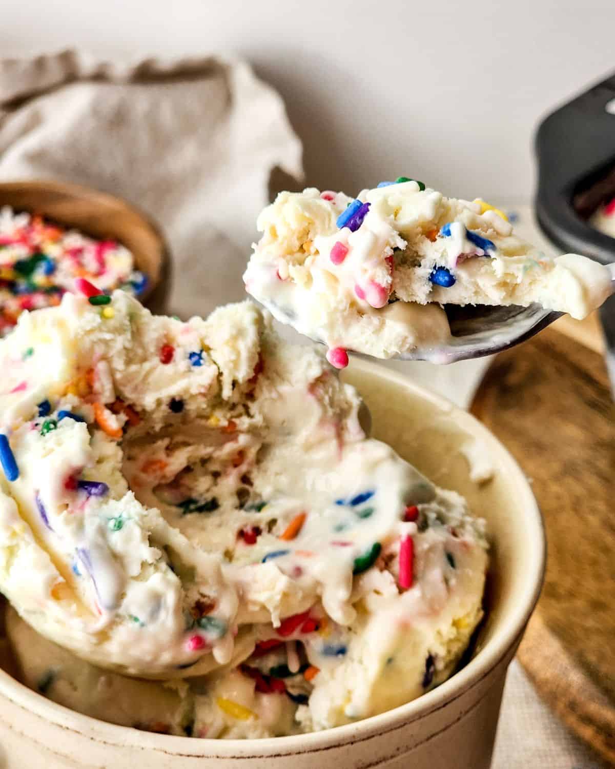Homemade birthday cake ice cream that is no churn and served in a large cup.