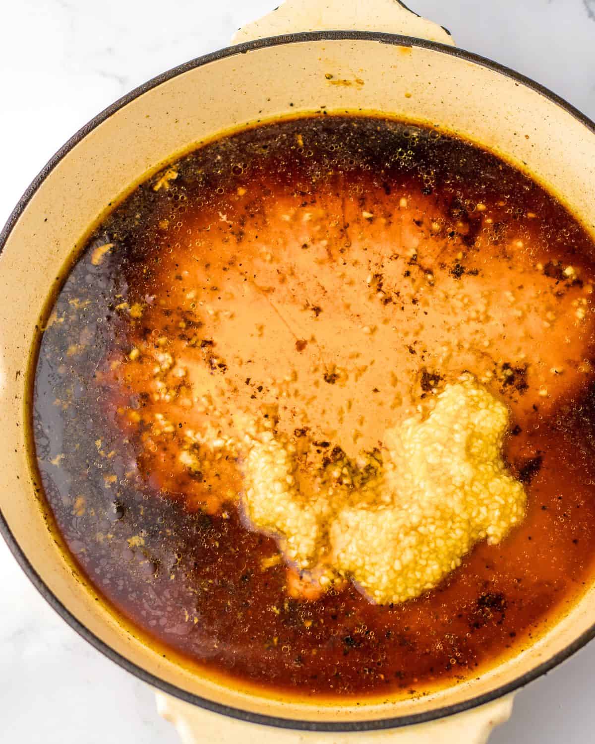 Honey and garlic sauce in a pan to make pork chops and potatoes.