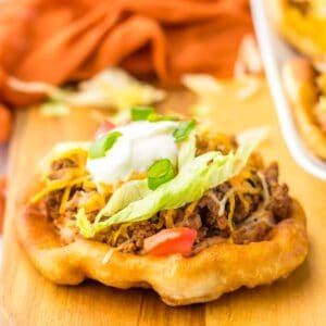 Indian fry bread taco topped with lettuce and sour cream.