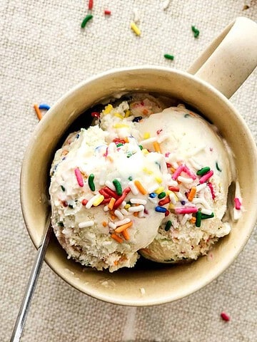 Birthday Cake Ice Cream topped with rainbow sprinkles in a mug.