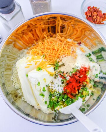 A mixing bowl with ingredients to make jalapeno poppers in the slow cooker.