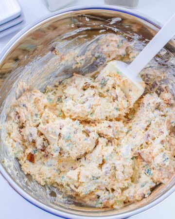 A mixing bowl with a creamy cheese blend with jalapenos to make jalapeno popper dip.