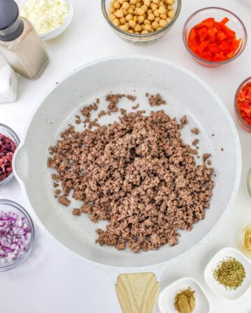 Browned ground beef in a saute pan.