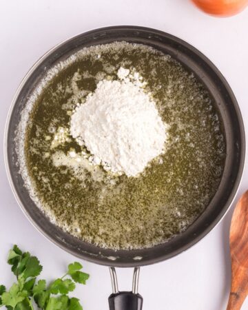 The sauce for making sour cream enchilada casserole in a large pan. 