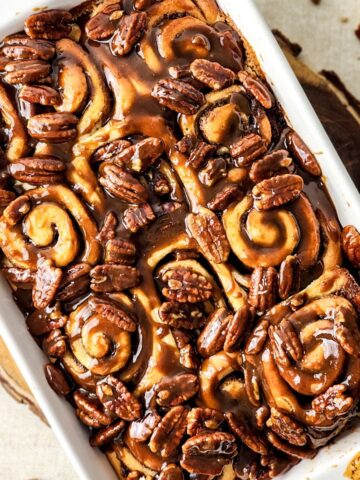 Brown sugar glazed Butter Pecan Sticky Buns in a large baking pan.