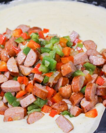 Cheese sauce with smoked sausage and peppers to make a cajun macaroni and cheese.