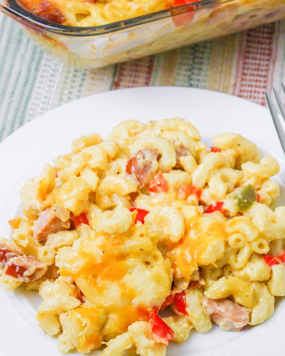Plated Cajun mac and cheese with smoked sausage and peppers in a creamy spicy sauce.