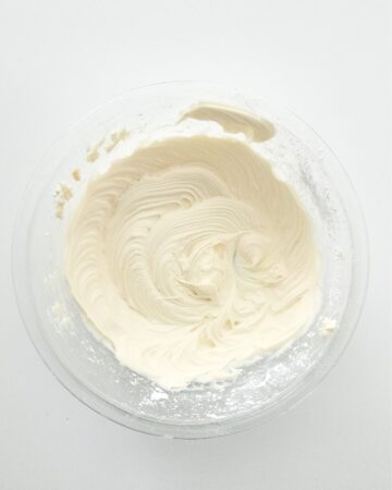 Whipped cream being whipped in a bowl.