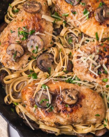Chicken Marsala Fettuccine with mushrooms in a cast iron pan.