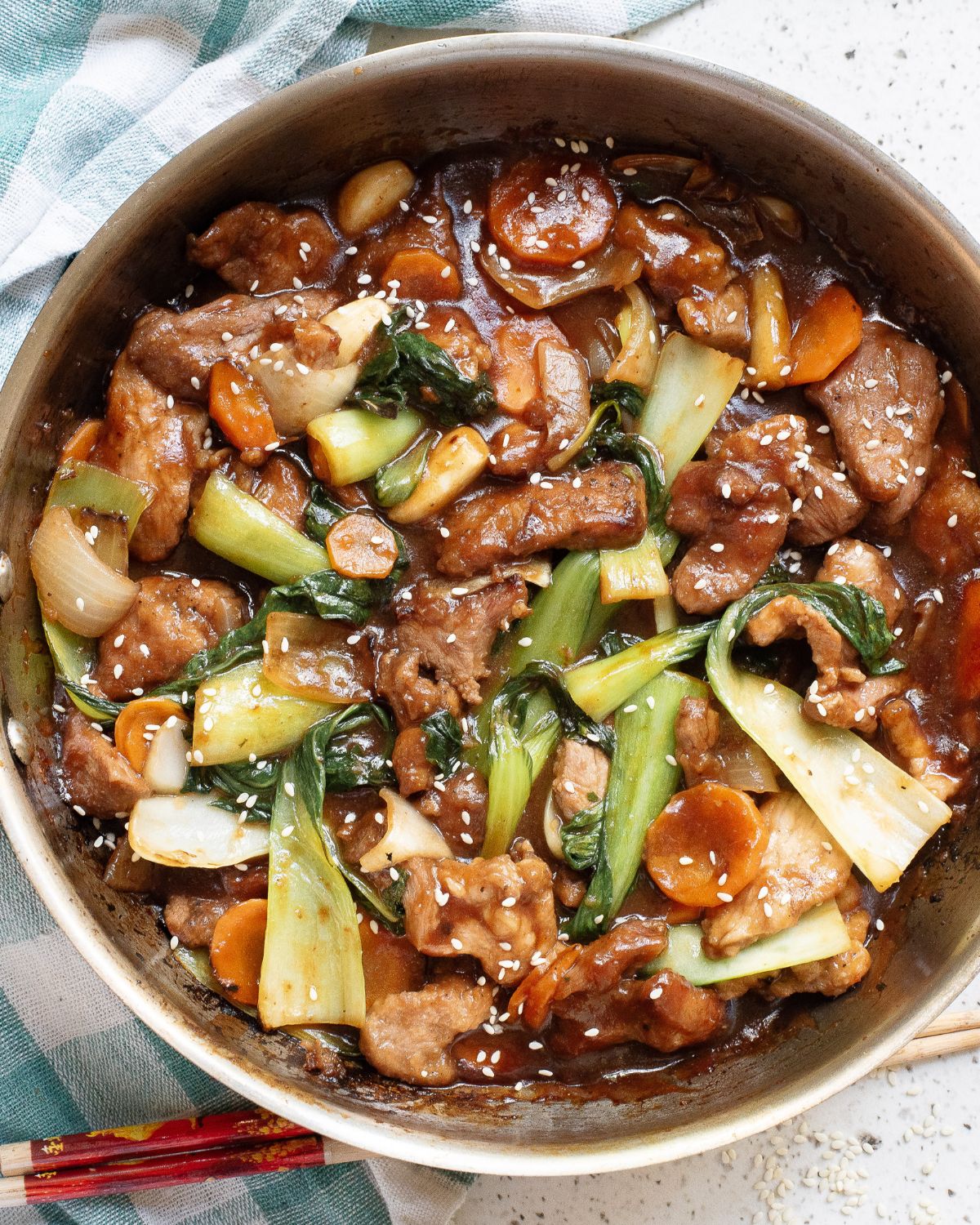 A pan of pork chop suey topped with sesame seeds.