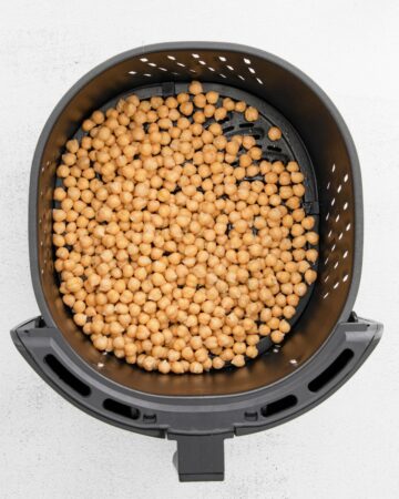 Chickpeas in an air fryer vessel.