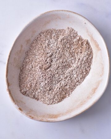 A bowl of a mixture of cinnamon, confectioners sugar, and brown sugar to make apple chips.