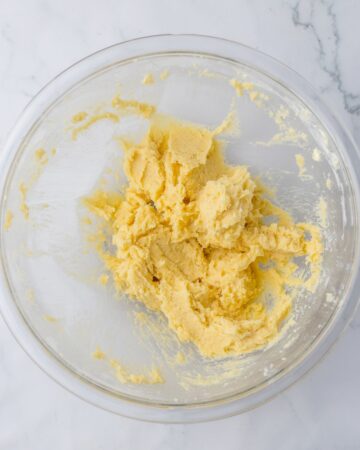 A glass bowl with butter,brown sugar, and white sugar whipped together for cookies.