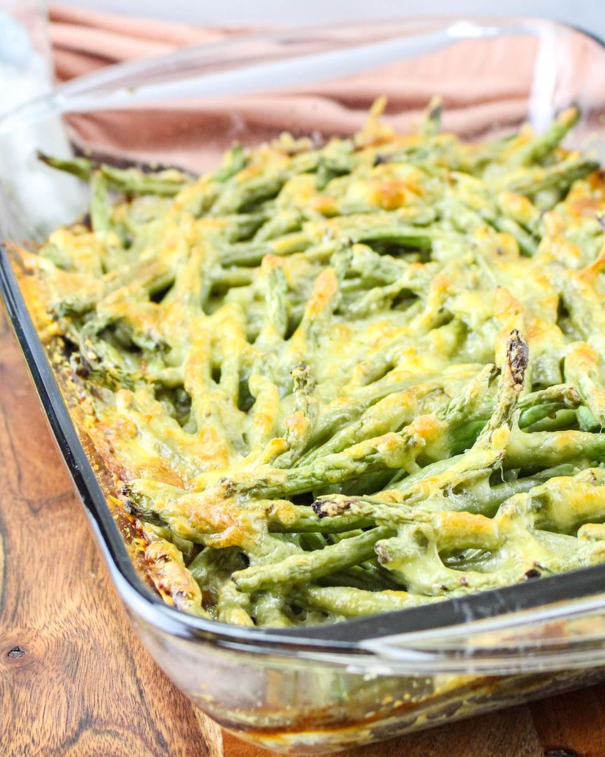 A casserole of green beans topped with a cheesy sauce. 