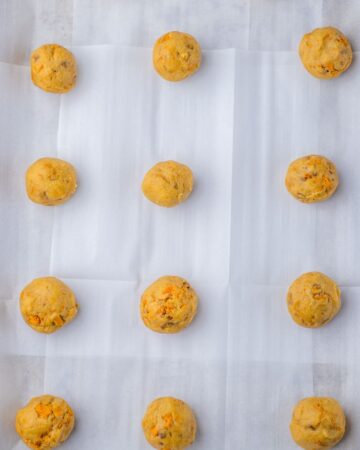 A cookie tray with cookie dough balls on the tray. 