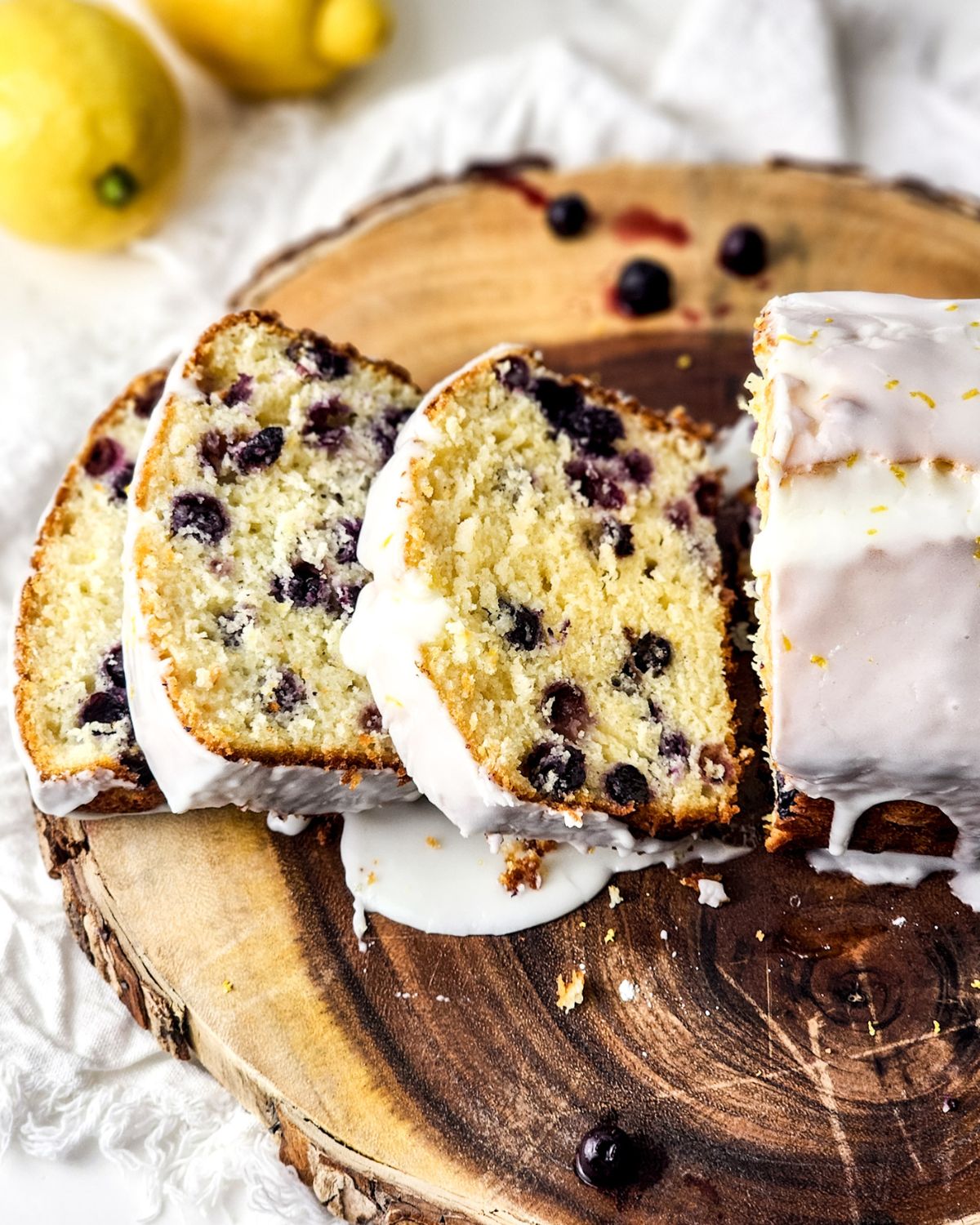 Sliced Blueberry lemon glazed bread on a wooden platter.