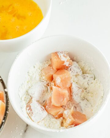 Chicken pieces in flour to make orange chicken. 