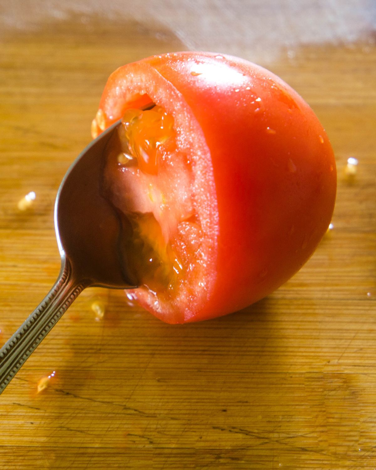 A tomato being seeded for pico de gallo. 