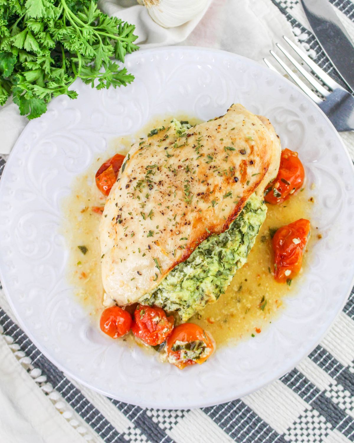 A large plate with a stuffed rigotta spinach chicken breast.