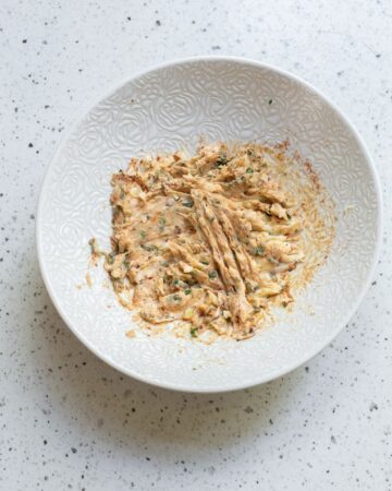 A bowl with unsalted butter with cajun seasoning and spices for a butter sauce for tilapia.