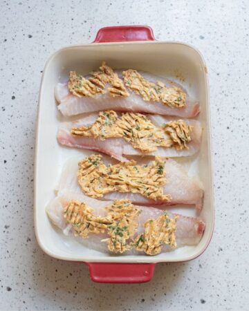 Tilapia fillets to be baked in a baking dish topped with a cajun lemon butter.