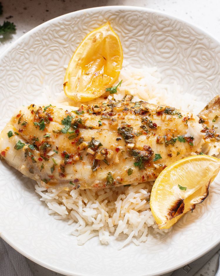 Baked tilapia with lemon and cajun spices over rice.
