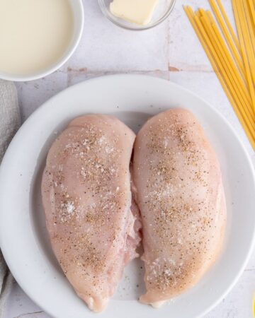 Chicken breasts seasoned with salt and pepper to make chicken alfredo linquine
