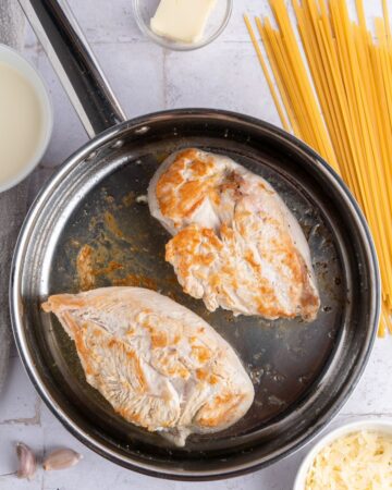 Chicken breasts browned to make alfredo with linquine.