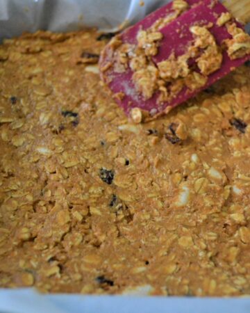 A mixture of cranberry pumpkin oat bars in a baking pan ready to go in the oven.