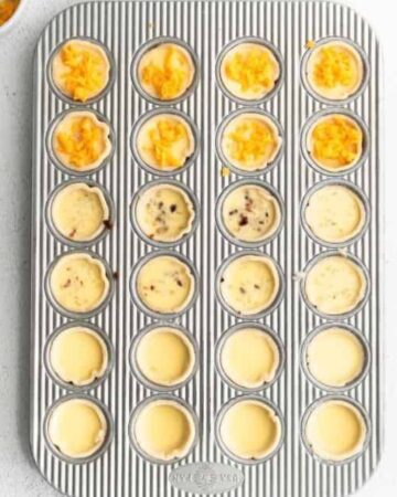 A mini muffin pan with egg mixture for mini quiche.
