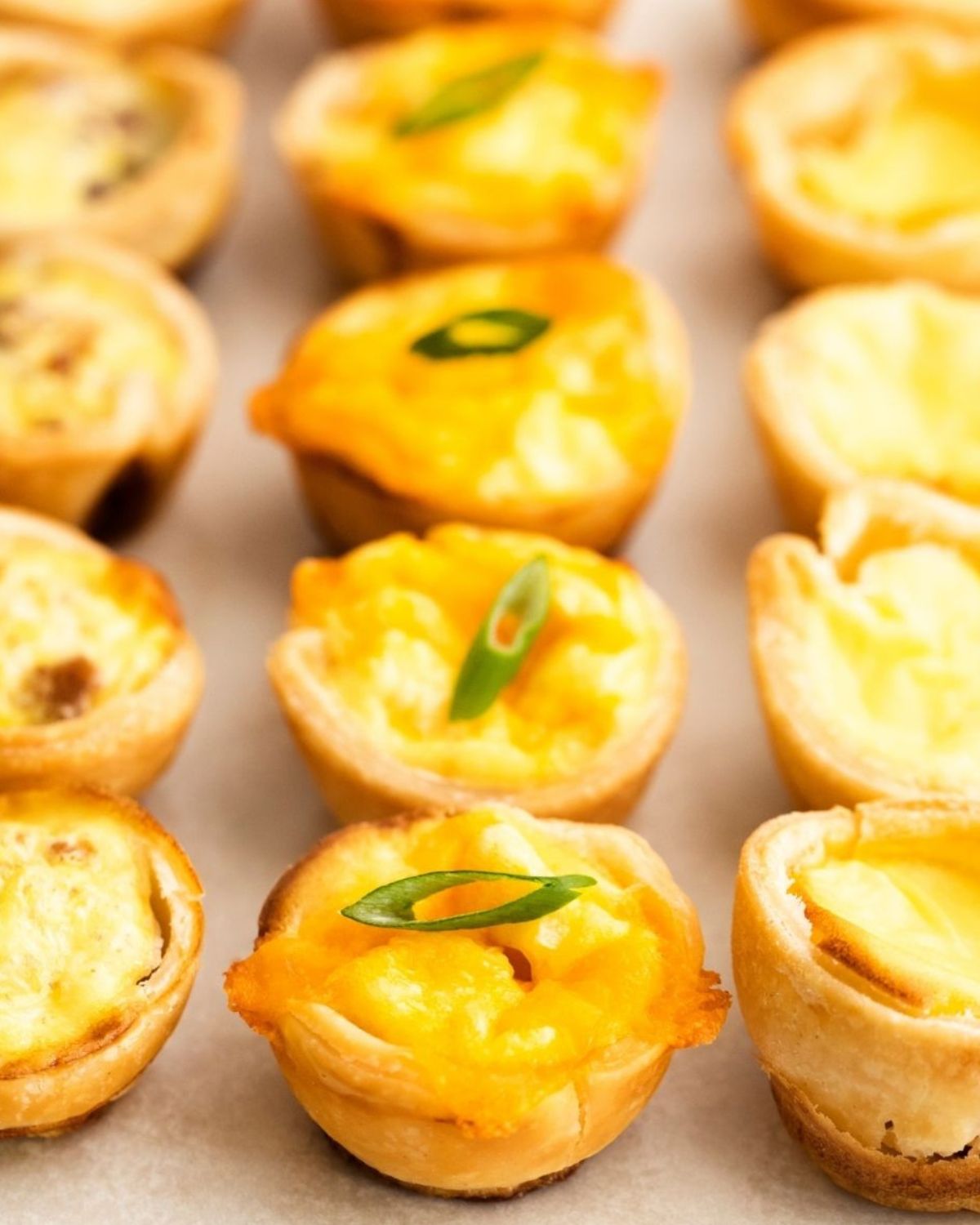 Mini quiche with chive, bacon, and cheese on a plate. 