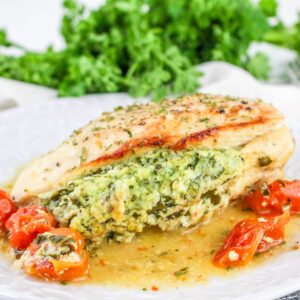 Stuffed chicken with ricotta cheese and spinach on a plate.