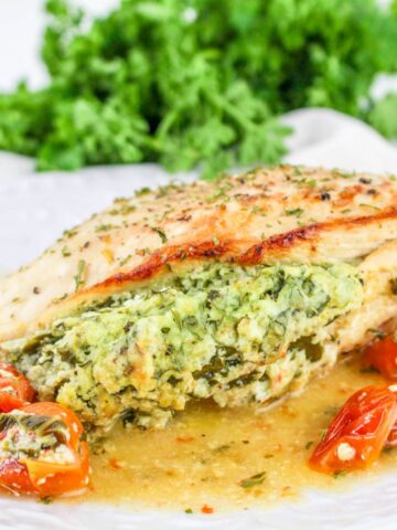 Stuffed chicken with ricotta cheese and spinach on a plate.