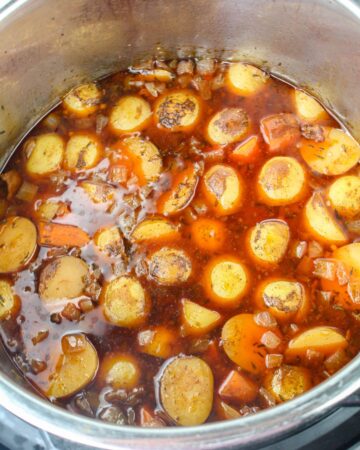 An instant pot with red wine and potatoes to make Instant pot beef Bourguignon.