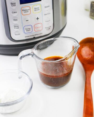 An Instant Pot with a measuring cup with Bourguignon sauce and flour to make a thicker sauce. 