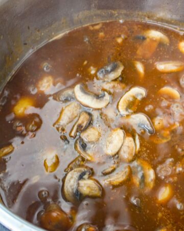 An instant pot vessel with mushrooms and beef in a Bourguignon sauce. 