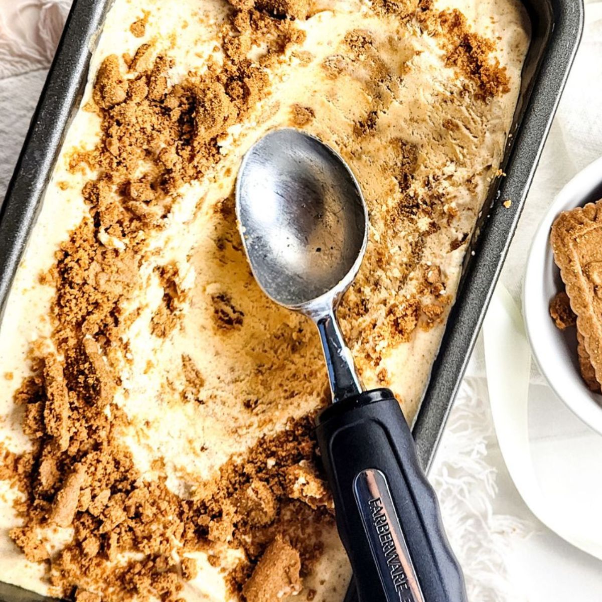 A loaf pan with pumpkin ice cream with a Biscoff cookie crumble.