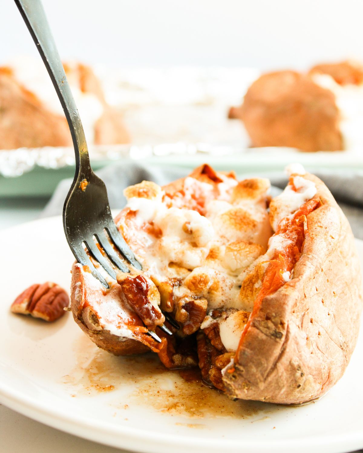 Baked sweet potatoes stuffed with butter pecans and topped with marshmallows.