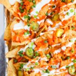 Baked buffalo chicken nachos topped with chedar cheese and ranch dressing.