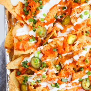 Baked buffalo chicken nachos topped with chedar cheese and ranch dressing.