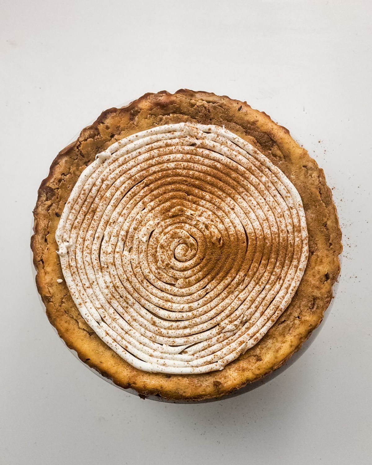 Cinnamon swirl cheesecake topped with a cream cheese frosting.