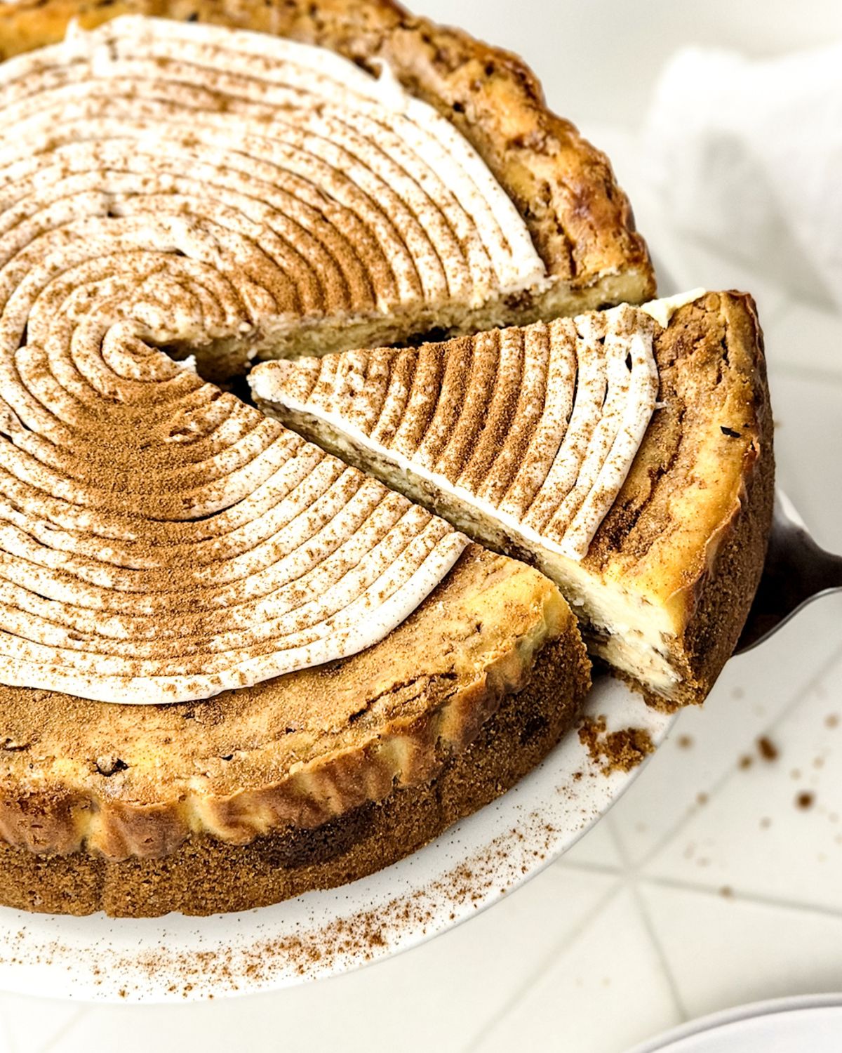 Cinnamon Roll Cheesecake being sliced.