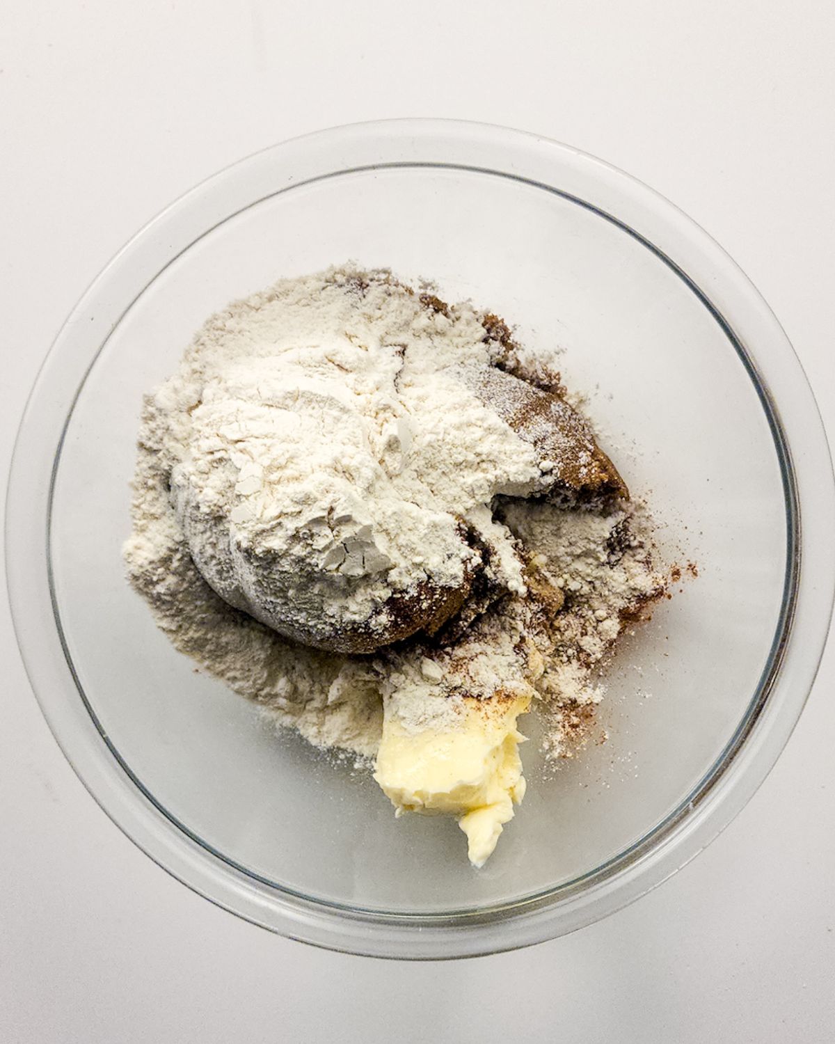 A glass bowl with cinnamon, flour, and butter to make a cinnamon swirl for a cinnamon swirl cheesecake. 