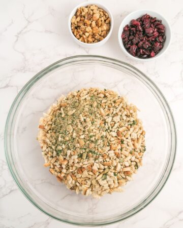 A glass bowl with stuffing mix with dried cranberries, and walnuts.